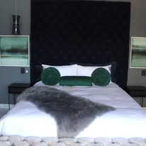 Navy velvet headboard king bed with crisp white linen